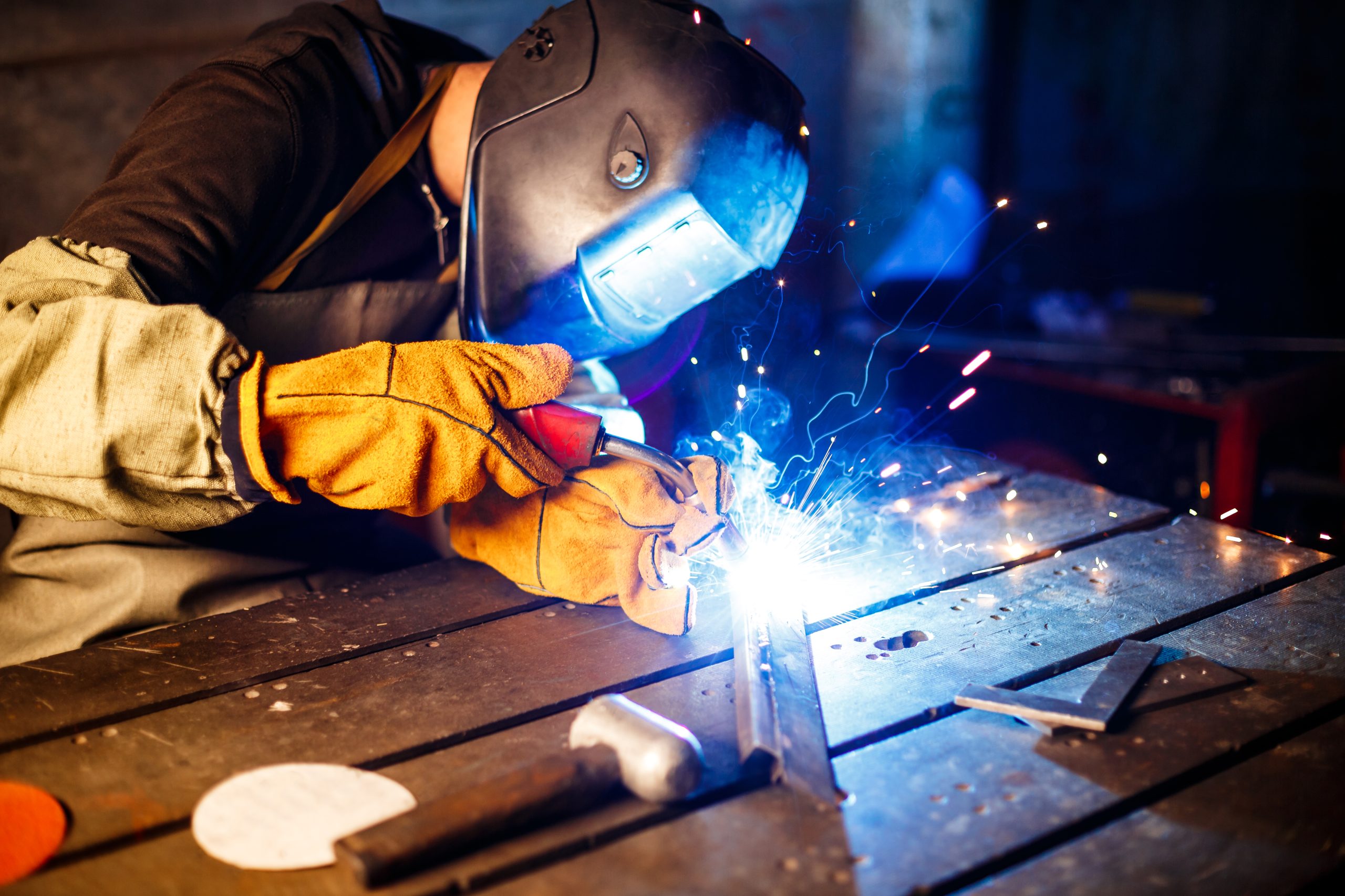 Worker cutting metal with plasma equipment on plant.